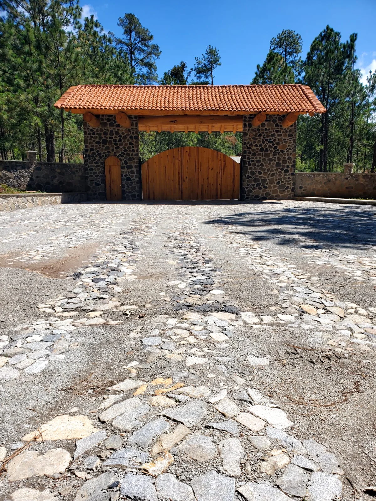 Entrada de Tlalli Residencial vista de frente desde el camino empedrado