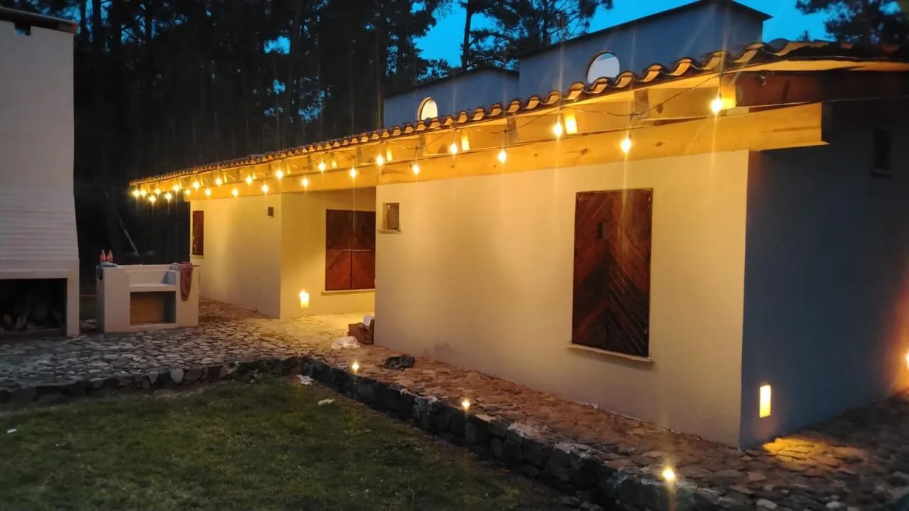 Terraza exterior con asador y serie de luces en una casa de Tlalli Residencial